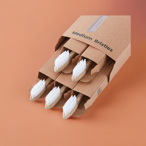 Eco Origin bamboo toothbrushes with white medium bristles in eco-friendly packaging. Eco Origin bamboo toothbrushes with white medium bristles in eco-friendly packaging.